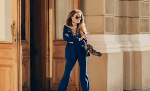 Mulher estilosa vestindo um traje azul completo e óculos escuros, exala confiança e modernidade.